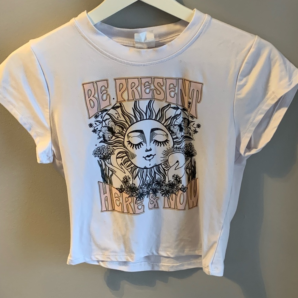 White “Be Present, Here, and Now” graphic tee.